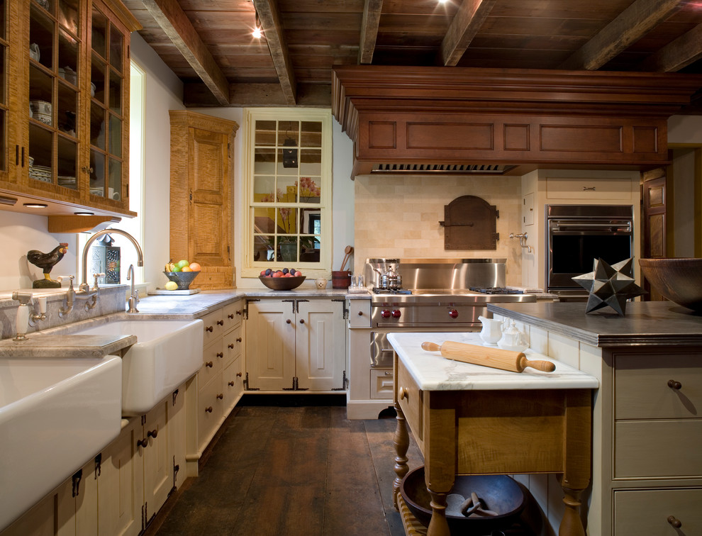 Inspiration for a large timeless l-shaped dark wood floor and brown floor enclosed kitchen remodel in Philadelphia with a farmhouse sink, travertine backsplash, recessed-panel cabinets, white cabinets, marble countertops, beige backsplash, stainless steel appliances and an island