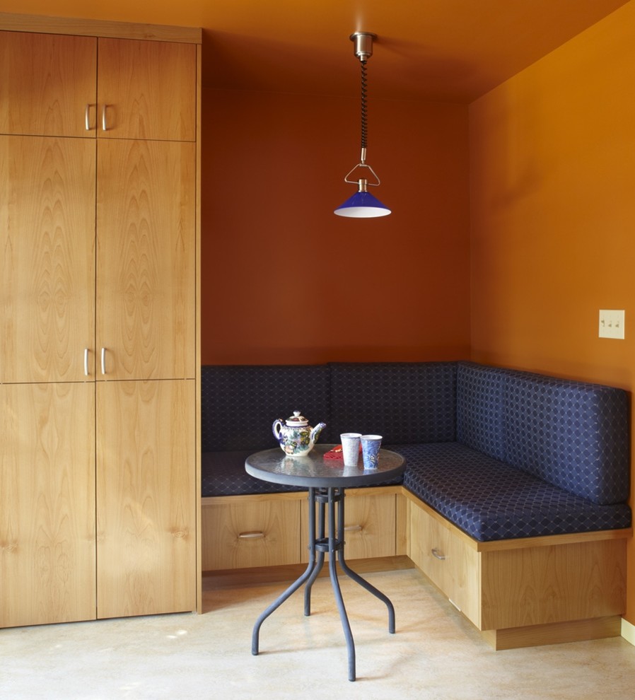 Idée de décoration pour une cuisine américaine design en bois clair de taille moyenne avec un placard à porte plane, un sol en calcaire et un sol beige.