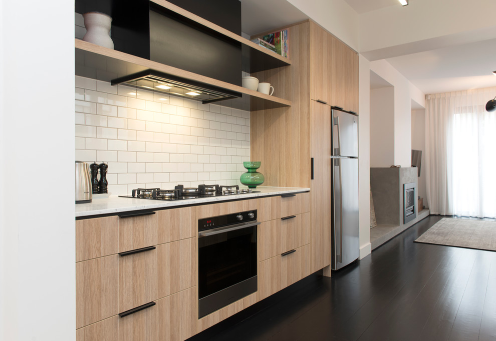 Foto di una cucina parallela design di medie dimensioni con top in marmo, paraspruzzi bianco e elettrodomestici in acciaio inossidabile