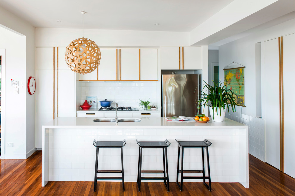 Kitchen - contemporary kitchen idea in Gold Coast - Tweed with flat-panel cabinets, white cabinets, white backsplash, stainless steel appliances and an island