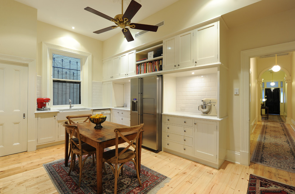 Exempel på ett stort modernt kök, med en rustik diskho, luckor med infälld panel, vita skåp, bänkskiva i koppar, vitt stänkskydd, stänkskydd i porslinskakel och ljust trägolv