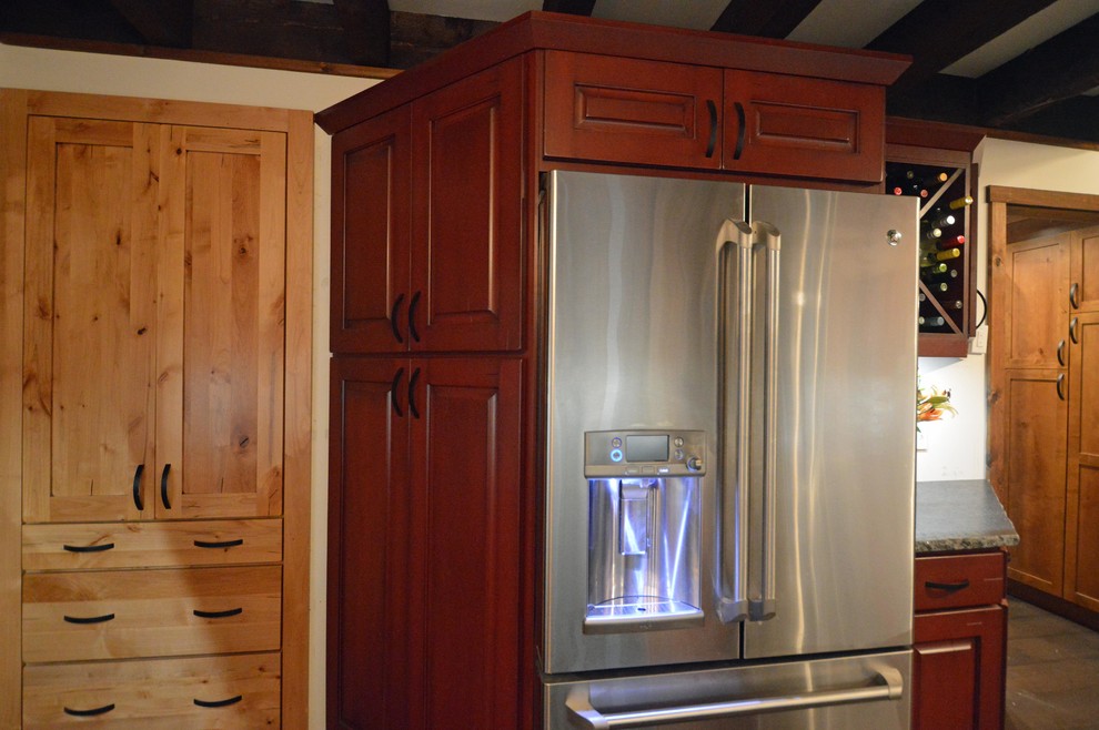 Exemple d'une cuisine montagne avec des portes de placard rouges et un plan de travail en granite.