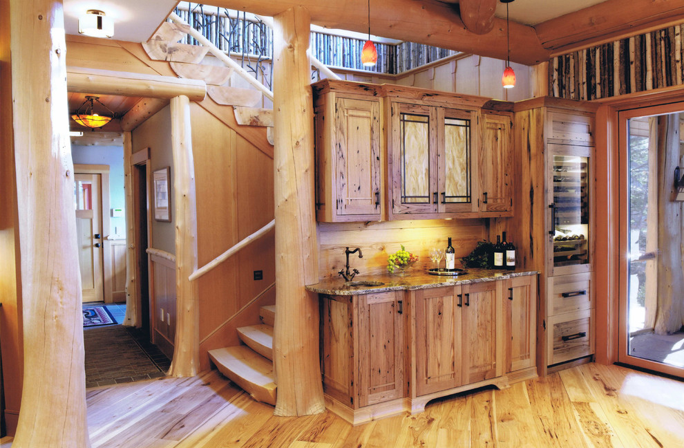 Cette image montre une cuisine chalet en bois brun avec un placard avec porte à panneau encastré.