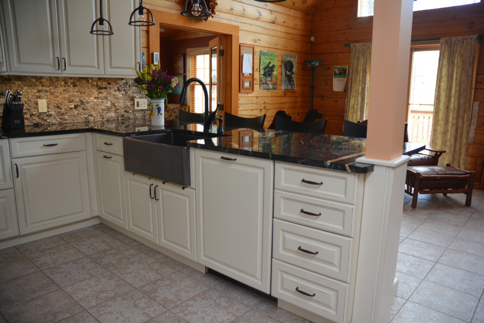 Exempel på ett mellanstort klassiskt svart svart kök, med en rustik diskho, luckor med upphöjd panel, vita skåp, granitbänkskiva, brunt stänkskydd, stänkskydd i stickkakel, rostfria vitvaror, klinkergolv i keramik, en halv köksö och flerfärgat golv