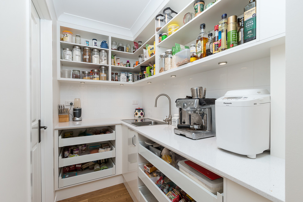 Bild på ett litet funkis kök, med en enkel diskho, öppna hyllor, vita skåp, granitbänkskiva, vitt stänkskydd, stänkskydd i keramik, rostfria vitvaror och ljust trägolv