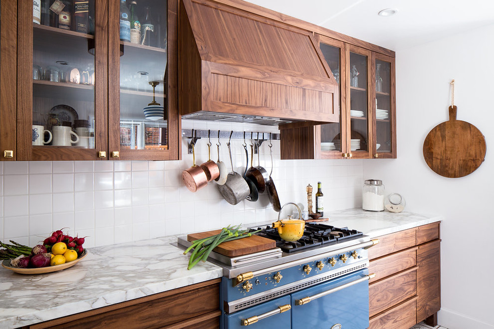 Cette photo montre une cuisine chic en bois foncé avec un placard à porte shaker, plan de travail en marbre, une crédence blanche, une crédence en céramique et un électroménager de couleur.
