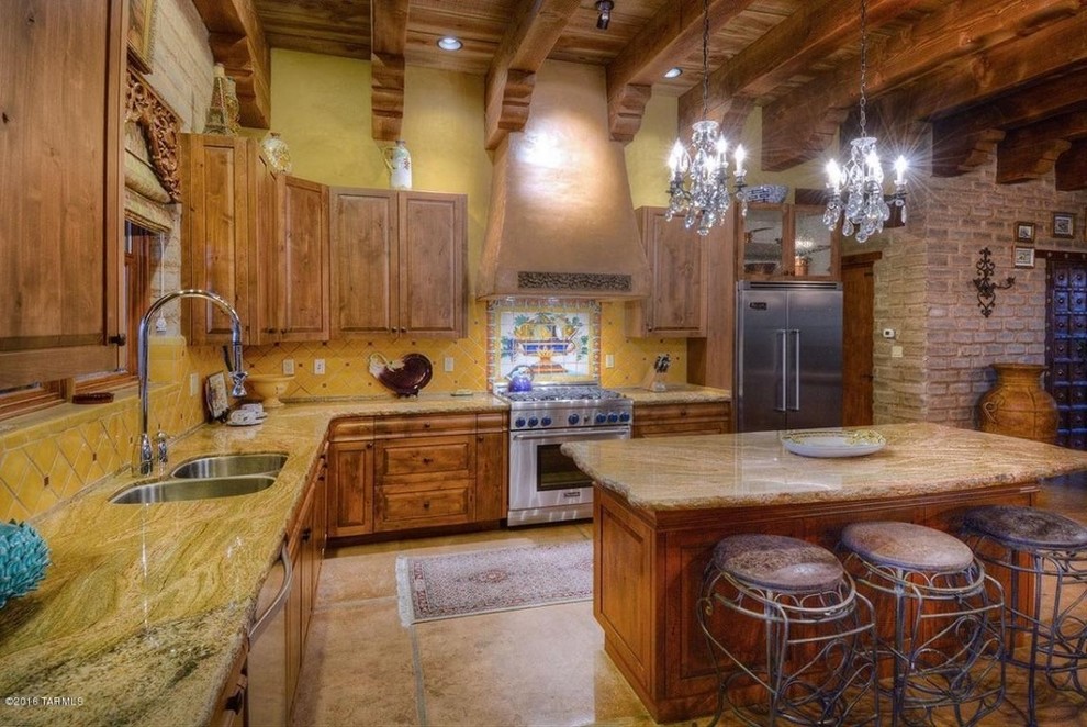 Example of a large southwest l-shaped ceramic tile eat-in kitchen design in Phoenix with a double-bowl sink, raised-panel cabinets, medium tone wood cabinets, granite countertops, yellow backsplash, ceramic backsplash, stainless steel appliances and an island
