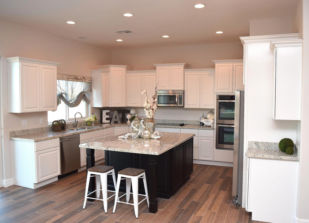 Mid-sized transitional u-shaped porcelain tile open concept kitchen photo in Phoenix with a double-bowl sink, raised-panel cabinets, white cabinets, granite countertops, gray backsplash, stone slab backsplash, stainless steel appliances and an island