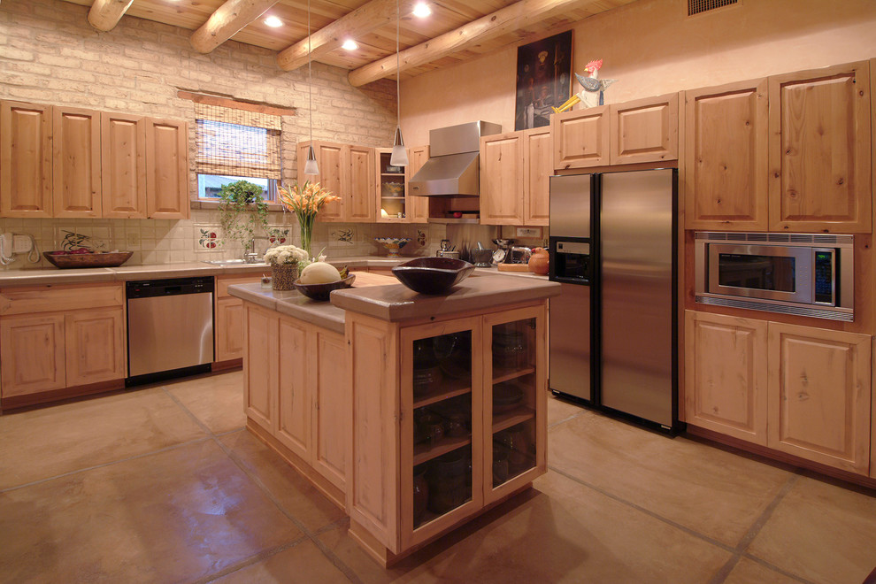 Inspiration for a large transitional l-shaped concrete floor open concept kitchen remodel in Phoenix with raised-panel cabinets, distressed cabinets, concrete countertops, white backsplash and stainless steel appliances