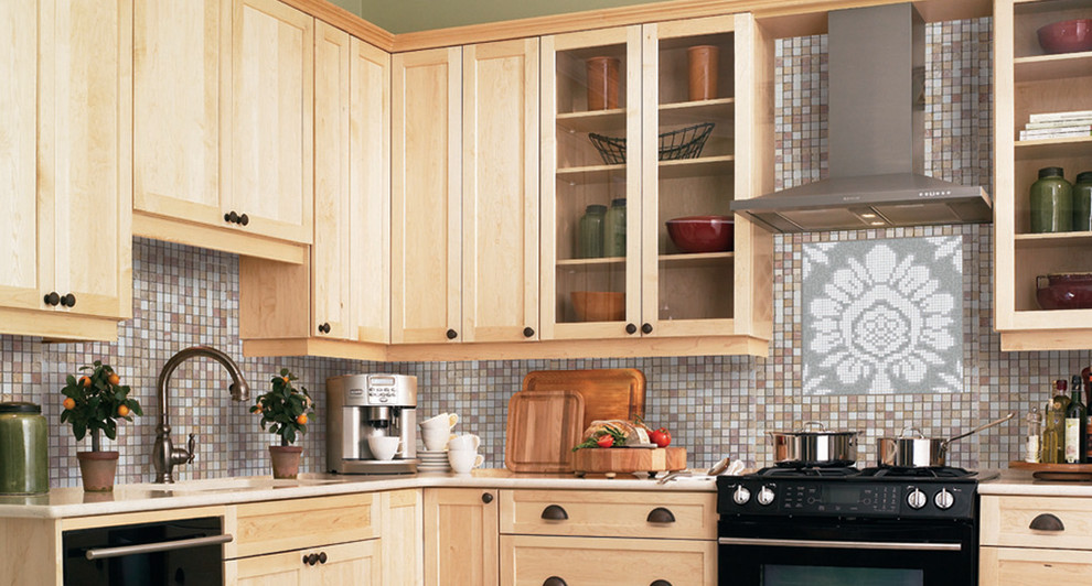 Aménagement d'une cuisine classique en bois clair avec un placard à porte vitrée, un électroménager noir, une crédence multicolore et une crédence en mosaïque.