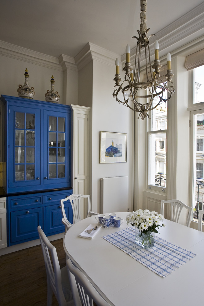 This is an example of a classic grey and cream kitchen/diner in London with blue cabinets.