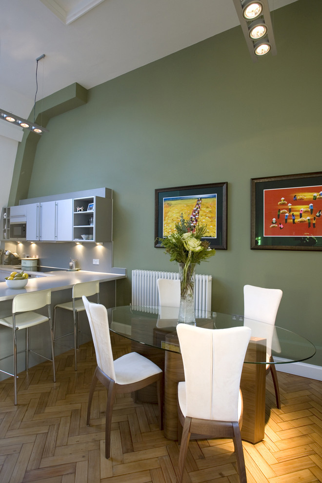 На фото: кухня в современном стиле с обеденным столом, плоскими фасадами, белыми фасадами и акцентной стеной
