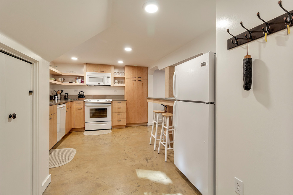 Idéer för att renovera ett litet funkis beige beige kök, med en nedsänkt diskho, släta luckor, skåp i ljust trä, bänkskiva i kvartsit, beige stänkskydd, stänkskydd i sten, vita vitvaror, betonggolv, en halv köksö och beiget golv