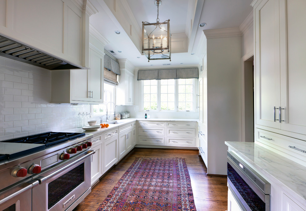 Imagen de cocina tradicional con salpicadero blanco, salpicadero de azulejos tipo metro y electrodomésticos de acero inoxidable