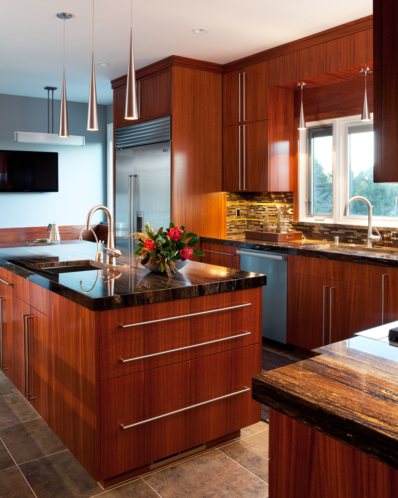 Foto på ett mellanstort funkis kök, med en undermonterad diskho, släta luckor, skåp i mellenmörkt trä, granitbänkskiva, grått stänkskydd, stänkskydd i stickkakel, rostfria vitvaror, klinkergolv i keramik, en köksö och brunt golv