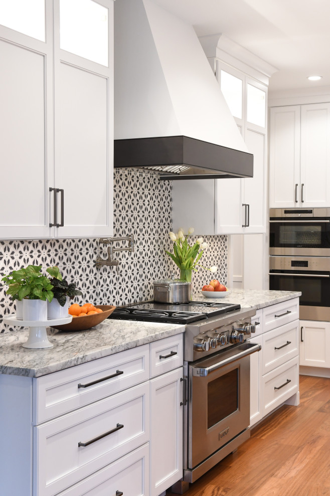 Bild på ett mellanstort vintage flerfärgad flerfärgat kök, med en undermonterad diskho, vita skåp, marmorbänkskiva, flerfärgad stänkskydd, stänkskydd i stenkakel, rostfria vitvaror, en köksö och brunt golv