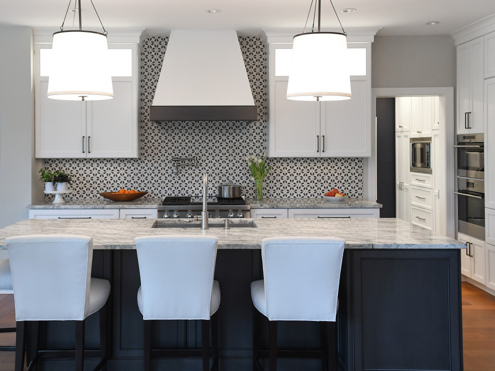 Klassisk inredning av ett mellanstort flerfärgad flerfärgat kök, med en undermonterad diskho, vita skåp, marmorbänkskiva, flerfärgad stänkskydd, stänkskydd i stenkakel, rostfria vitvaror, en köksö och brunt golv