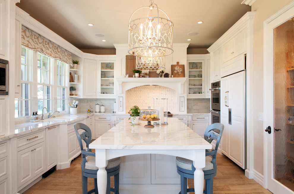 Inspiration for a large timeless u-shaped enclosed kitchen remodel in Orange County with an undermount sink, raised-panel cabinets, white cabinets, gray backsplash, subway tile backsplash, paneled appliances, an island and quartz countertops