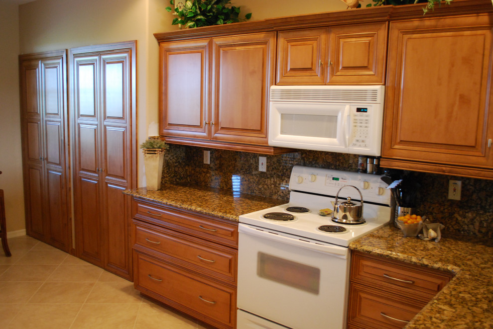 Foto på ett avskilt, mellanstort eklektiskt u-kök, med en dubbel diskho, luckor med infälld panel, skåp i mellenmörkt trä, granitbänkskiva, beige stänkskydd, stänkskydd i keramik, vita vitvaror, klinkergolv i keramik, en köksö och beiget golv