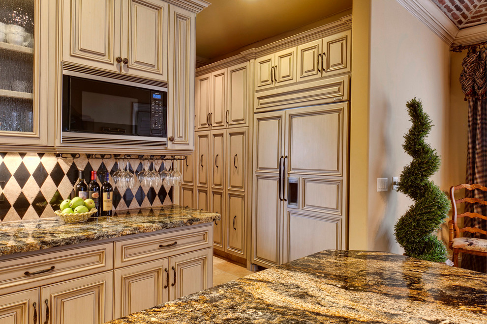 他の地域にあるトラディショナルスタイルのおしゃれなキッチン (レイズドパネル扉のキャビネット、ベージュのキャビネット、マルチカラーのキッチンパネル、パネルと同色の調理設備) の写真