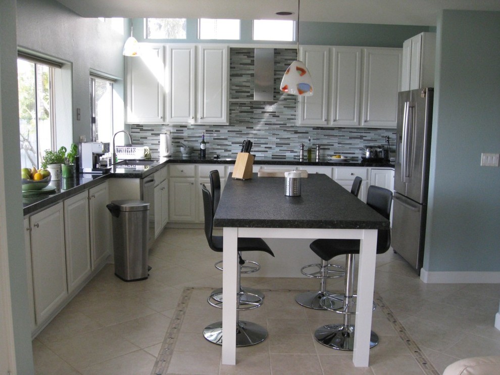 Immagine di una cucina minimalista chiusa e di medie dimensioni con lavello a doppia vasca, ante con bugna sagomata, ante bianche, paraspruzzi grigio, elettrodomestici in acciaio inossidabile e top nero