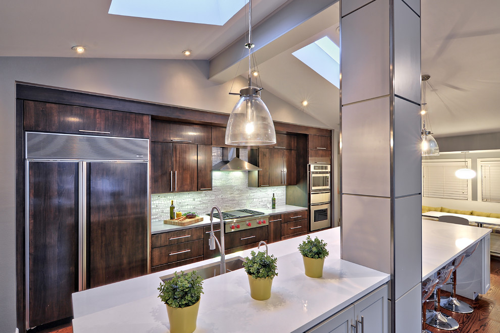 Inspiration for a mid-sized contemporary single-wall medium tone wood floor open concept kitchen remodel in Austin with an undermount sink, flat-panel cabinets, dark wood cabinets, quartz countertops, gray backsplash and stainless steel appliances