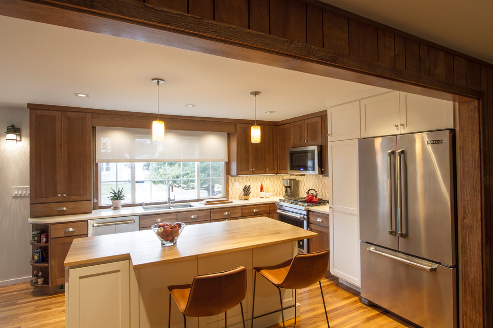 Exempel på ett mellanstort klassiskt beige beige kök, med en dubbel diskho, skåp i shakerstil, skåp i mellenmörkt trä, träbänkskiva, beige stänkskydd, stänkskydd i marmor, rostfria vitvaror, mellanmörkt trägolv, en köksö och brunt golv