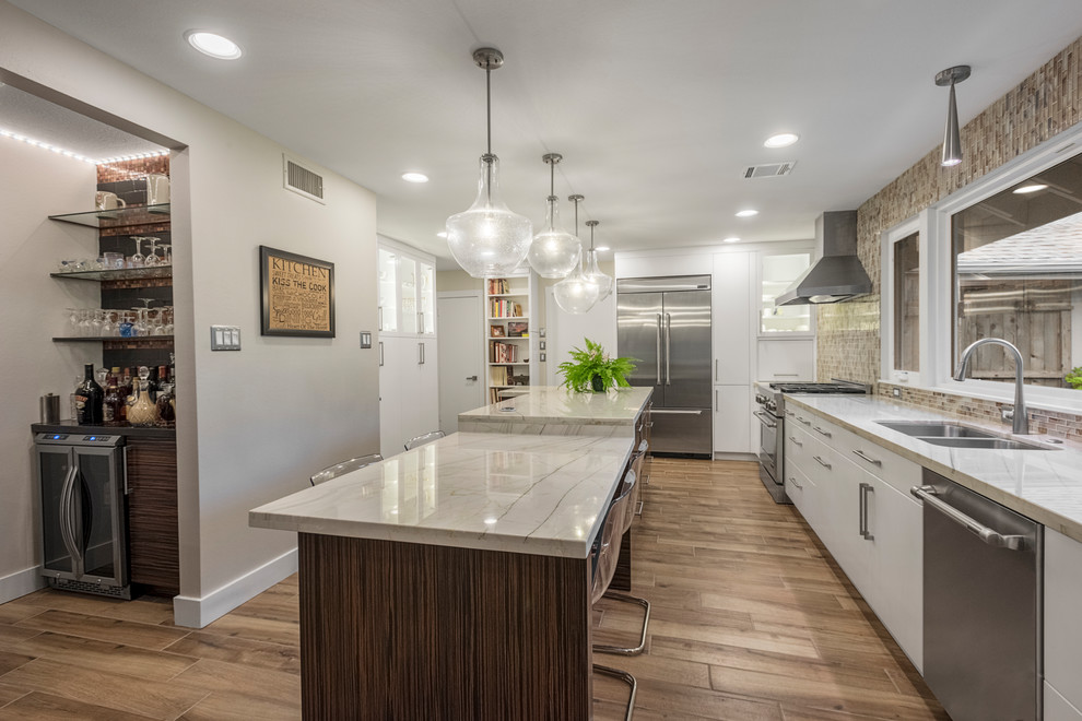 Kitchen - large transitional porcelain tile and multicolored floor kitchen idea in Houston with an undermount sink, flat-panel cabinets, white cabinets, quartzite countertops, multicolored backsplash, glass tile backsplash, stainless steel appliances and an island