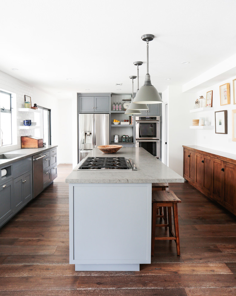 Klassische Küche mit Schrankfronten im Shaker-Stil, grauen Schränken, Küchengeräten aus Edelstahl, braunem Holzboden und Kücheninsel in Los Angeles