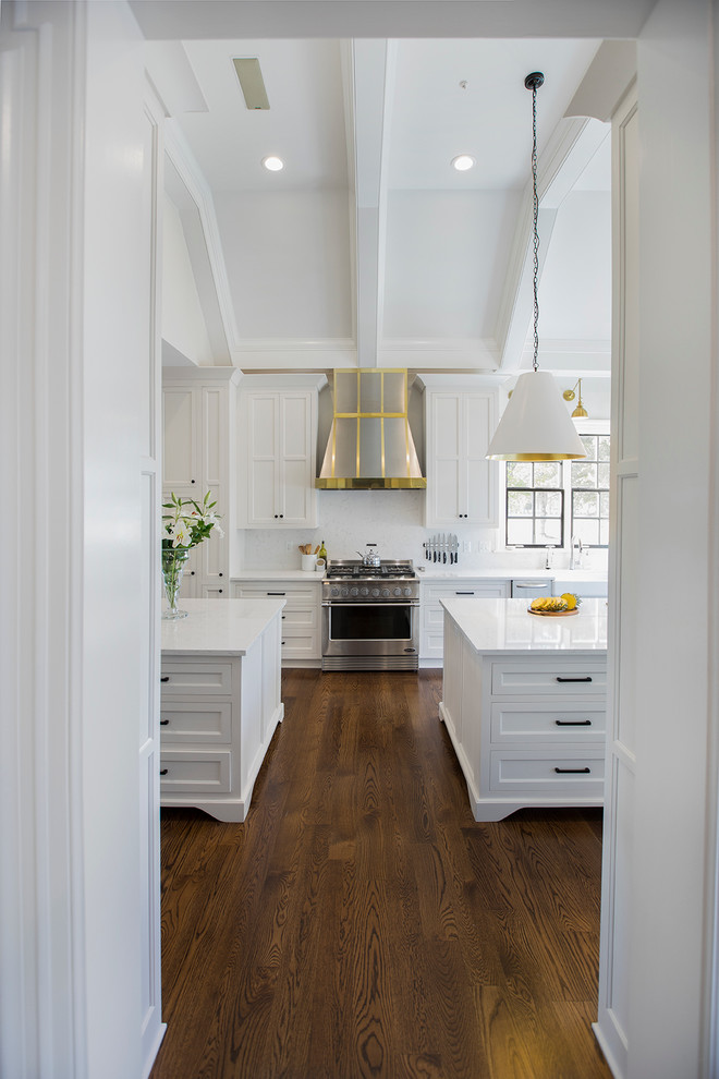 Idéer för mellanstora vintage kök, med flera köksöar, luckor med upphöjd panel, vita skåp, marmorbänkskiva, vitt stänkskydd, stänkskydd i glaskakel, rostfria vitvaror, ljust trägolv, brunt golv och en rustik diskho