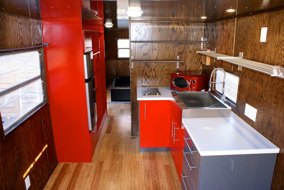 Foto di una piccola cucina moderna con lavello integrato, nessun'anta, paraspruzzi marrone, elettrodomestici colorati e pavimento in laminato