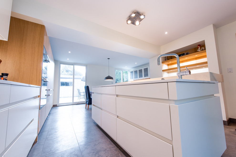 Wohnküche mit flächenbündigen Schrankfronten, weißen Schränken, Küchenrückwand in Orange, Rückwand aus Holz und Kücheninsel in Toronto