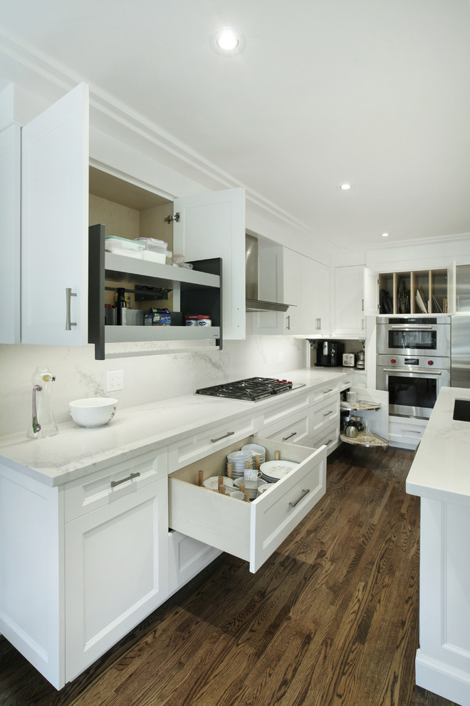 Foto di una cucina chic con lavello sottopiano, ante in stile shaker, ante bianche, elettrodomestici in acciaio inossidabile e pavimento in legno massello medio