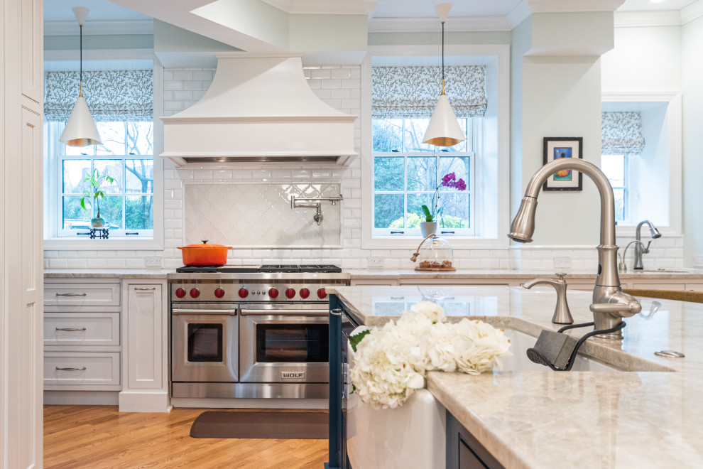 Example of a large transitional medium tone wood floor and brown floor eat-in kitchen design in Philadelphia with an undermount sink, recessed-panel cabinets, white cabinets, quartzite countertops, white backsplash, porcelain backsplash, stainless steel appliances, an island and white countertops