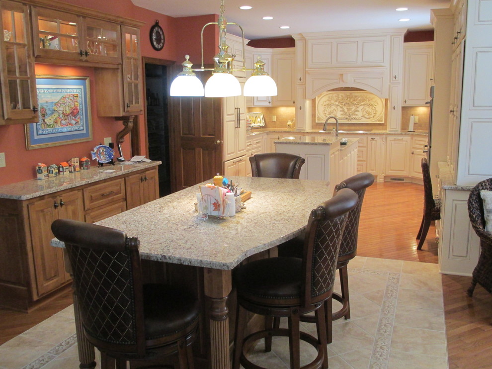 Example of a classic eat-in kitchen design in St Louis with an undermount sink, white cabinets, granite countertops and paneled appliances