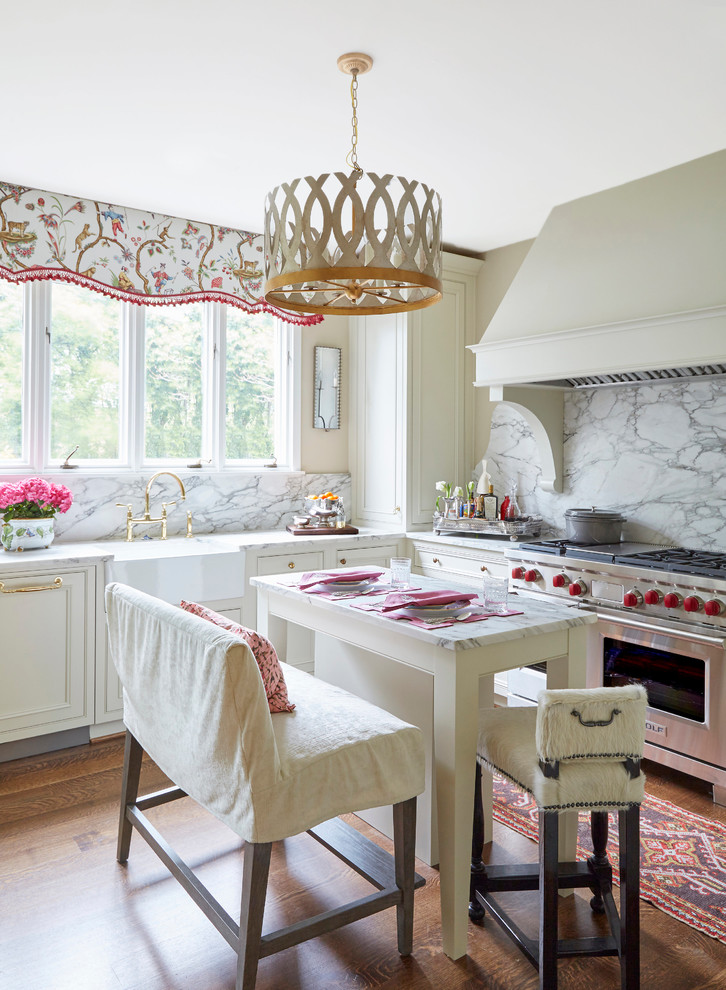 Eat-in kitchen - mid-sized traditional dark wood floor eat-in kitchen idea in Birmingham with a farmhouse sink, beaded inset cabinets, white cabinets, marble countertops, white backsplash, stone slab backsplash, stainless steel appliances and an island