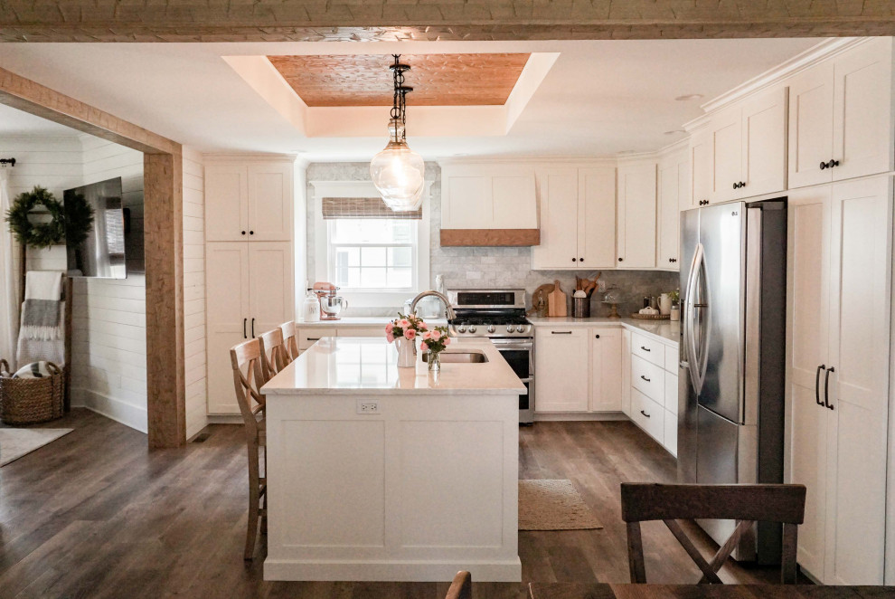 Idéer för ett mellanstort lantligt vit kök, med en undermonterad diskho, skåp i shakerstil, vita skåp, bänkskiva i kvarts, grått stänkskydd, stänkskydd i marmor, rostfria vitvaror, mellanmörkt trägolv, en köksö och brunt golv