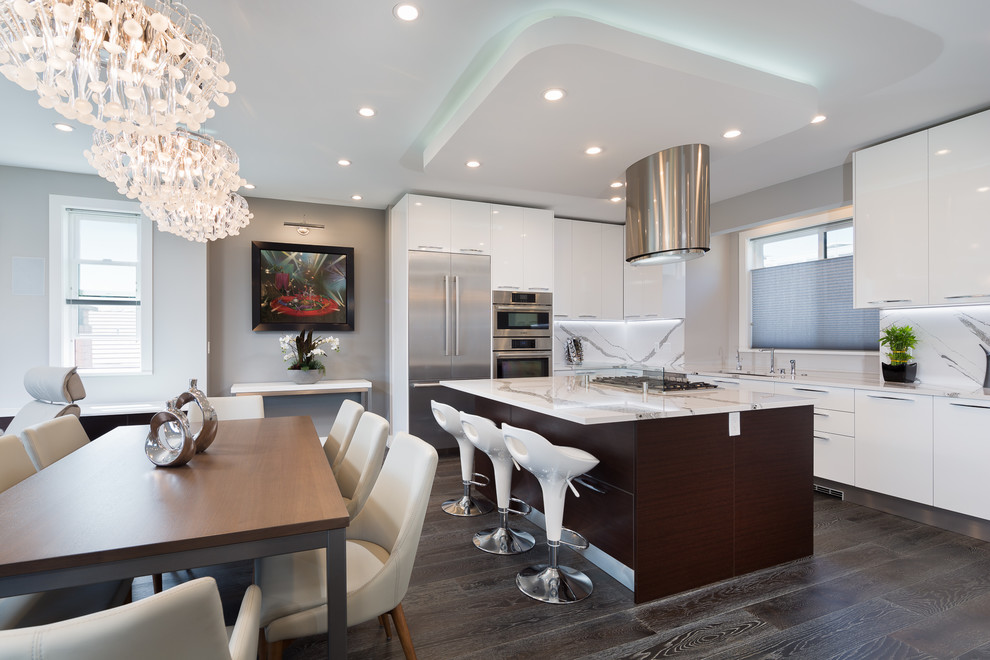 Example of a mid-sized minimalist u-shaped medium tone wood floor and gray floor eat-in kitchen design in Vancouver with an undermount sink, flat-panel cabinets, white cabinets, granite countertops, white backsplash, stone slab backsplash, stainless steel appliances, an island and white countertops