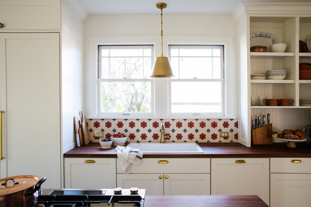 Foto di una cucina stile americano chiusa e di medie dimensioni con ante in stile shaker, ante bianche, top in legno, paraspruzzi con piastrelle di cemento e elettrodomestici da incasso