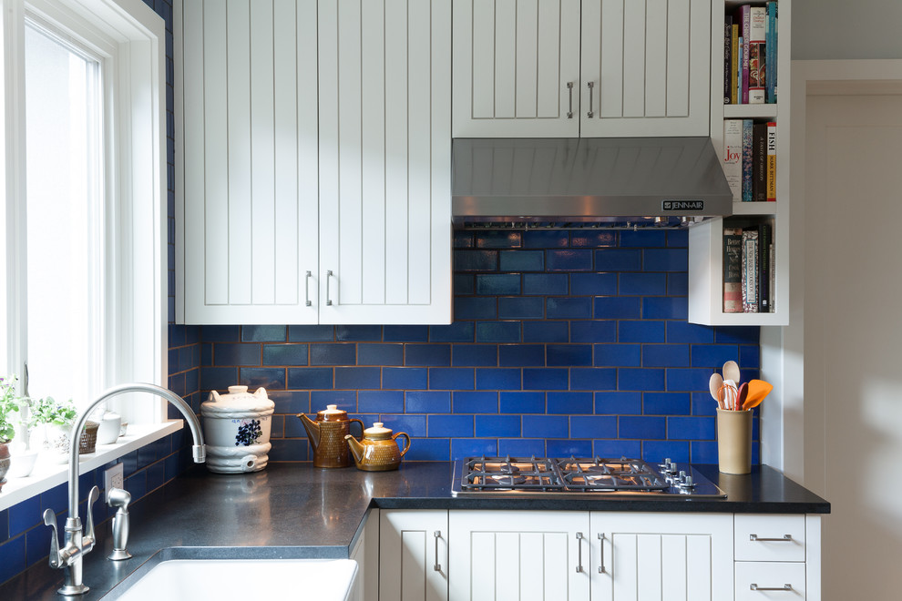 Eat-in kitchen - contemporary u-shaped eat-in kitchen idea in Portland with stainless steel appliances, a farmhouse sink, white cabinets, granite countertops, blue backsplash, subway tile backsplash and recessed-panel cabinets