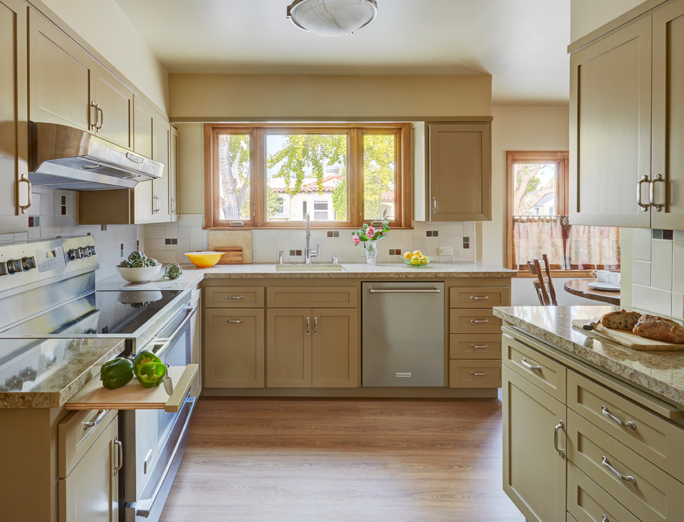 Classic l-shaped kitchen in San Francisco with a submerged sink, shaker cabinets, beige cabinets, white splashback, stainless steel appliances, light hardwood flooring, brown floors and beige worktops.