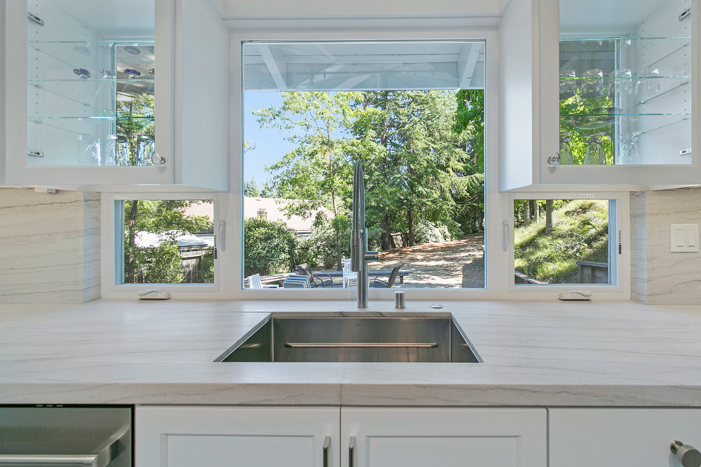 Exempel på ett stort modernt grå linjärt grått kök med öppen planlösning, med en undermonterad diskho, skåp i shakerstil, vita skåp, bänkskiva i kvartsit, grått stänkskydd, stänkskydd i sten, rostfria vitvaror, betonggolv, en köksö och grått golv