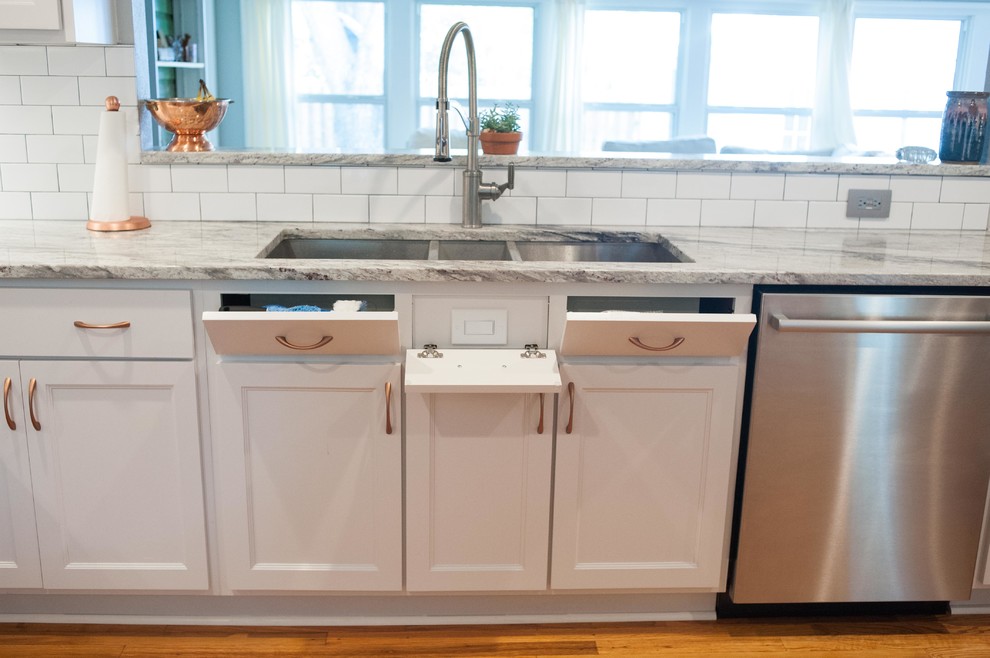 Inspiration for a large timeless u-shaped medium tone wood floor and multicolored floor eat-in kitchen remodel in Austin with a triple-bowl sink, shaker cabinets, white cabinets, granite countertops, white backsplash, subway tile backsplash, stainless steel appliances and a peninsula