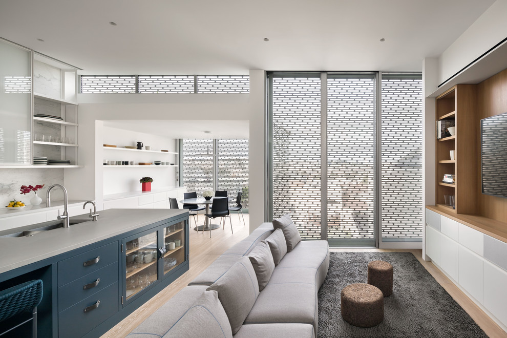 Example of a large trendy light wood floor eat-in kitchen design in San Francisco with glass-front cabinets, blue cabinets, concrete countertops, white backsplash, marble backsplash, stainless steel appliances and an island