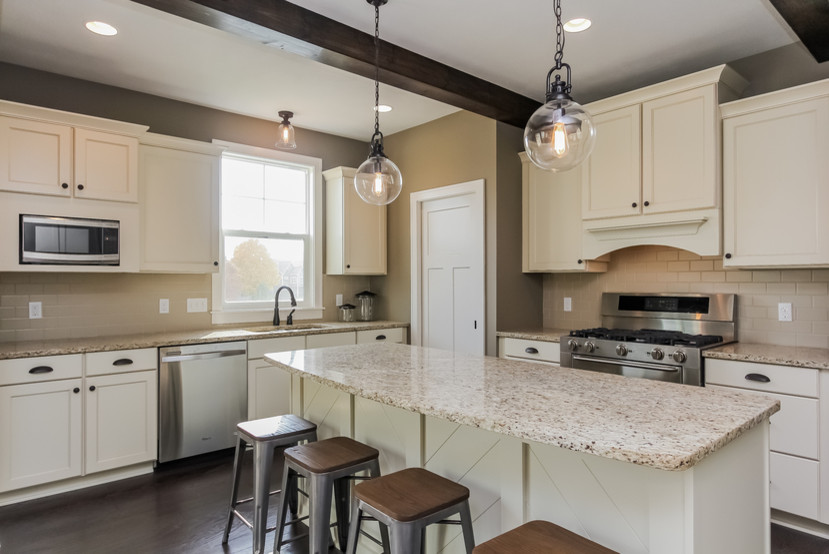 Example of a large arts and crafts u-shaped dark wood floor eat-in kitchen design in Grand Rapids with an undermount sink, raised-panel cabinets, white cabinets, granite countertops, beige backsplash, ceramic backsplash, stainless steel appliances and an island