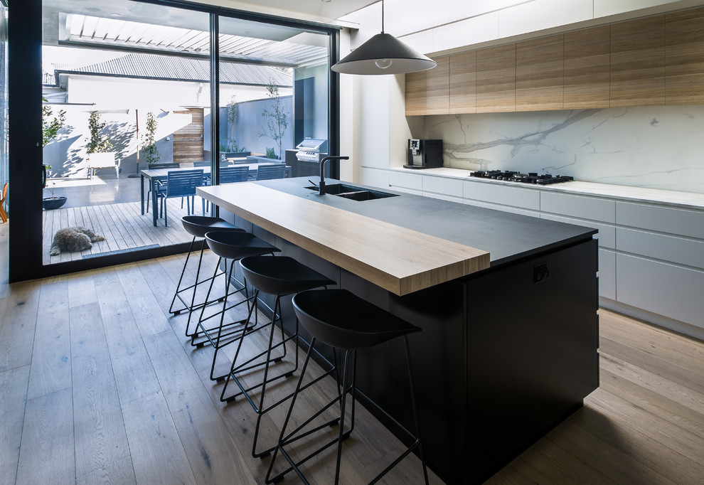 Photo of a medium sized modern l-shaped kitchen/diner in Melbourne with flat-panel cabinets, medium wood cabinets, marble worktops and an island.