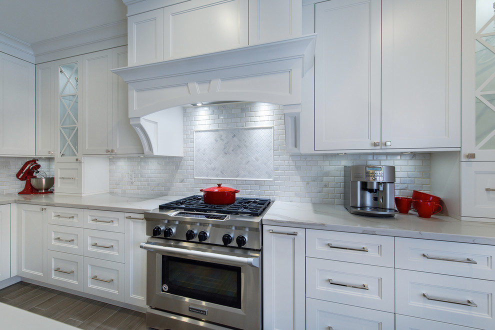 Exempel på ett stort klassiskt kök, med en undermonterad diskho, skåp i shakerstil, vita skåp, bänkskiva i kvarts, vitt stänkskydd, stänkskydd i marmor, rostfria vitvaror, klinkergolv i porslin, en köksö och grått golv