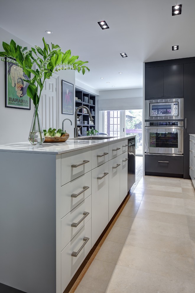 This is an example of a small contemporary galley kitchen/diner in Toronto with a double-bowl sink, flat-panel cabinets, grey cabinets, engineered stone countertops, grey splashback, porcelain splashback, stainless steel appliances, travertine flooring and an island.