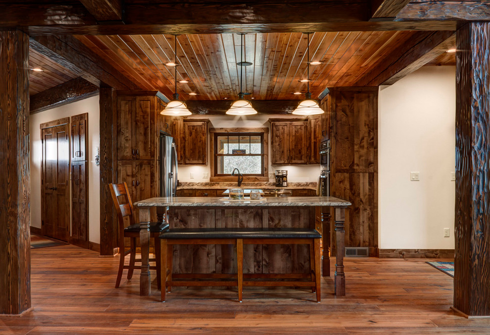 Example of a small mountain style galley medium tone wood floor eat-in kitchen design in Other with an undermount sink, shaker cabinets, medium tone wood cabinets, laminate countertops, white backsplash, stainless steel appliances and two islands
