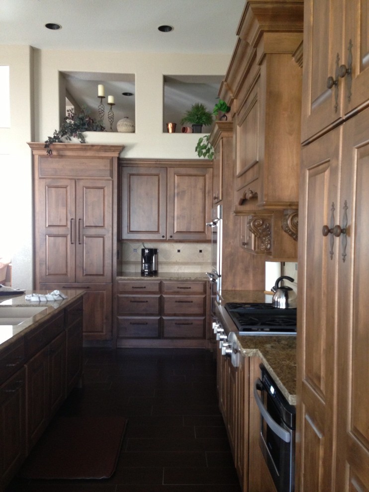Bild på ett vintage kök, med luckor med upphöjd panel, skåp i mellenmörkt trä, granitbänkskiva och beige stänkskydd